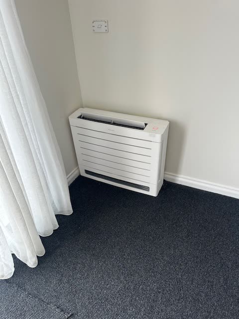 Floor mounted split system console installed at skirting level.