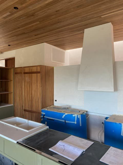 Kitchen with a lined timber ceiling and ducted air outlets set into it.
