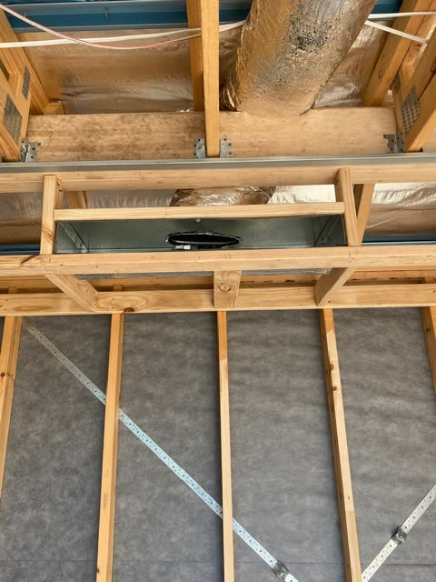 Supply air box boxed into the floor and ceiling framing from below, with flexible duct connected to the spigot.